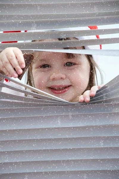 Bambina che guarda attraverso le tende — Foto Stock
