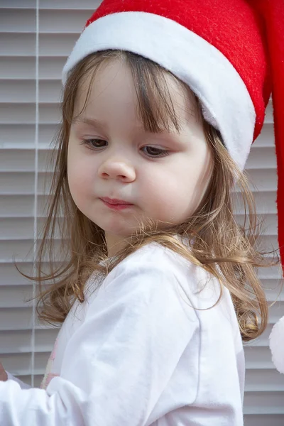 Mrňavá holka v čepici santa claus — Stock fotografie