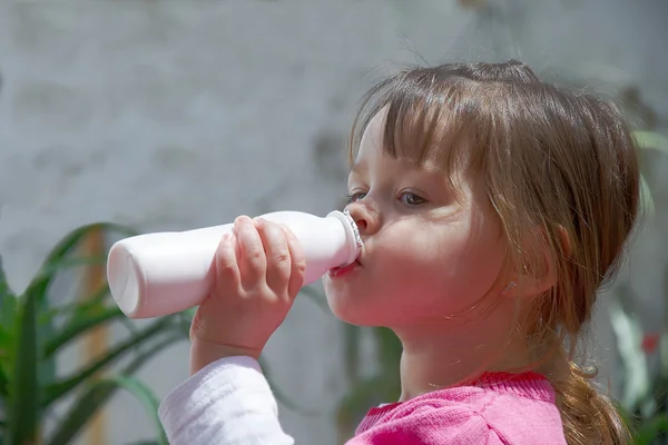 Маленькая девочка пьет йогурт — стоковое фото