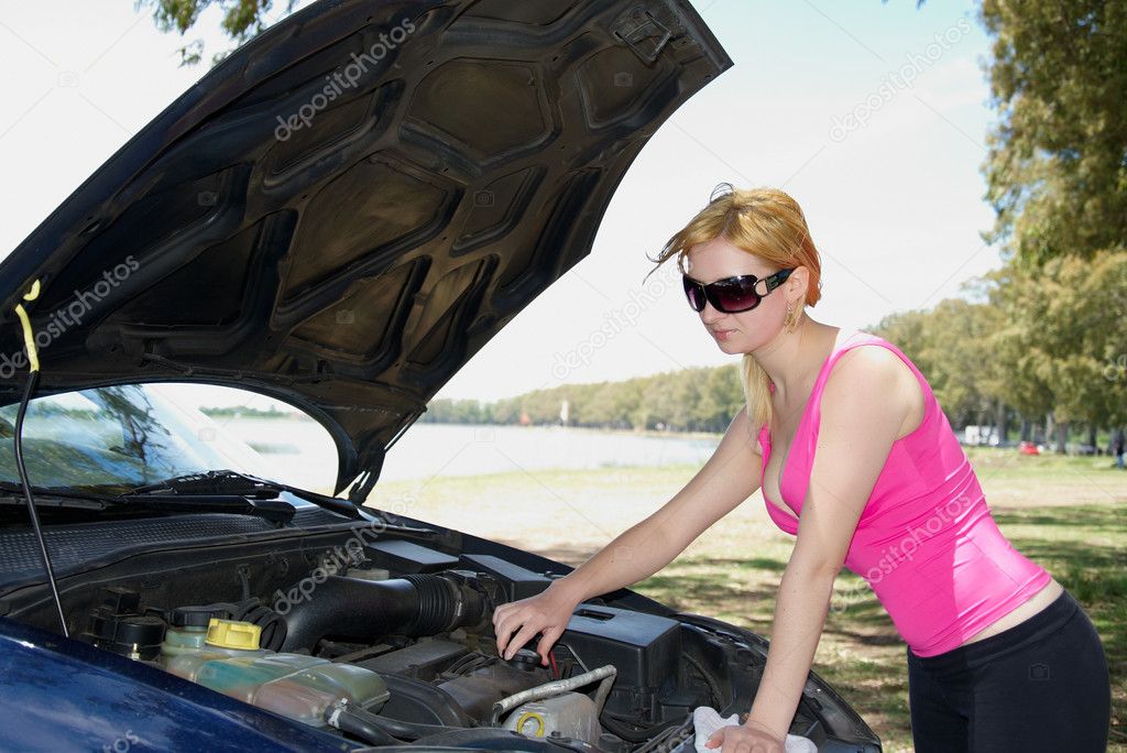 Beautiful girl repairing the car engine outdors