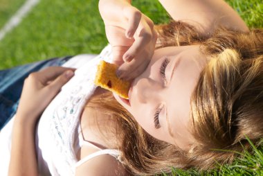 Beautiful girl is bitten by cereal bars clipart