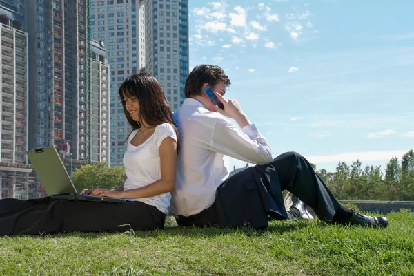 Mann und Frau sitzen in einem Park — Stockfoto