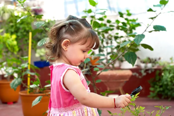Klein meisje in een tuin — Stockfoto