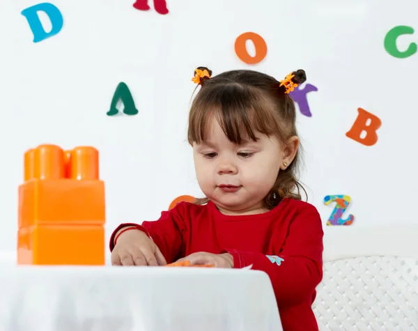 Menina joga um cubos coloridos — Fotografia de Stock