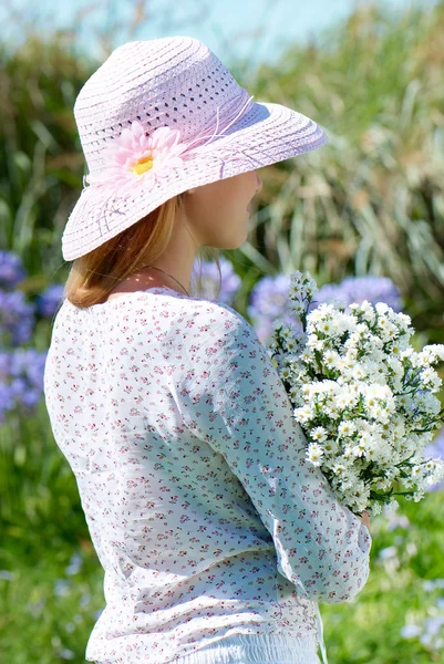 Dívka v klobouku s květinami — Stock fotografie