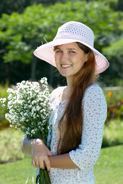 Meisje in de hoed met bloemen — Stockfoto