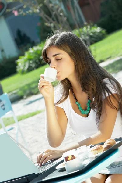 Beautiful girl eating in a cafe on the street — Stock Photo, Image