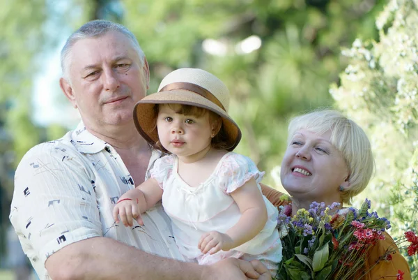 Kleines Mädchen mit Großvater und Großmutter im Park — Stockfoto