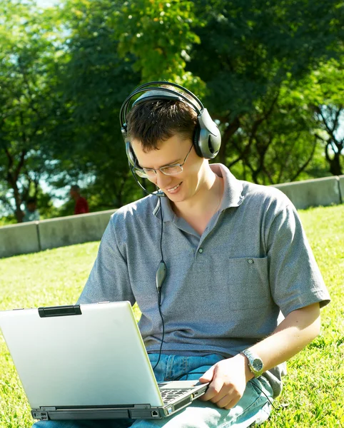 Guy escucha música en un portátil — Foto de Stock
