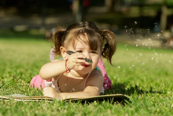 Little girl laying in grass — Stock Photo, Image