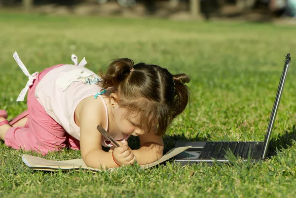 Маленька дівчинка малює в парку — стокове фото
