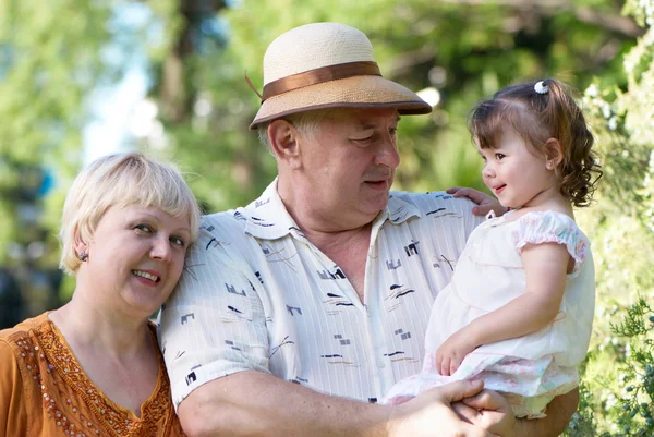 Маленькая девочка с дедушкой и бабушкой в парке — стоковое фото