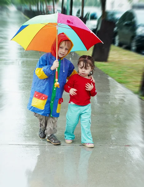 Meisje en jongen in de regen — Stockfoto