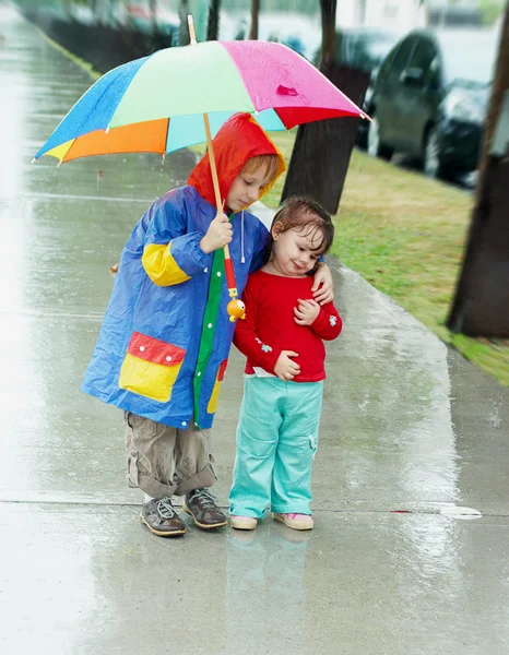 Девочка и мальчик под дождем — стоковое фото