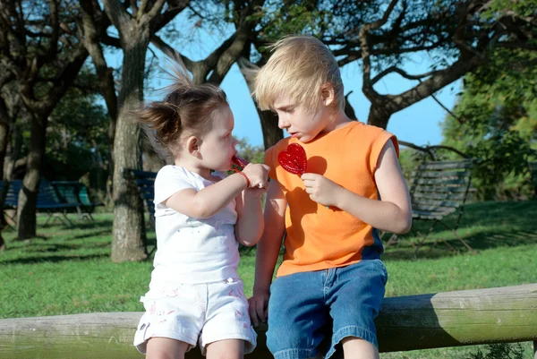 Jongen en meisje zit in het park — Stockfoto