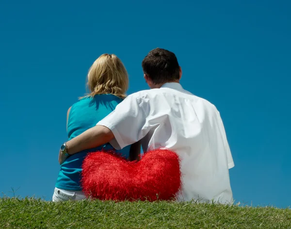 Muž a žena, sedící v trávě — Stock fotografie