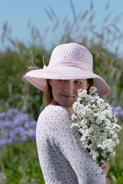 Meisje in een hoed met bloemen — Stockfoto