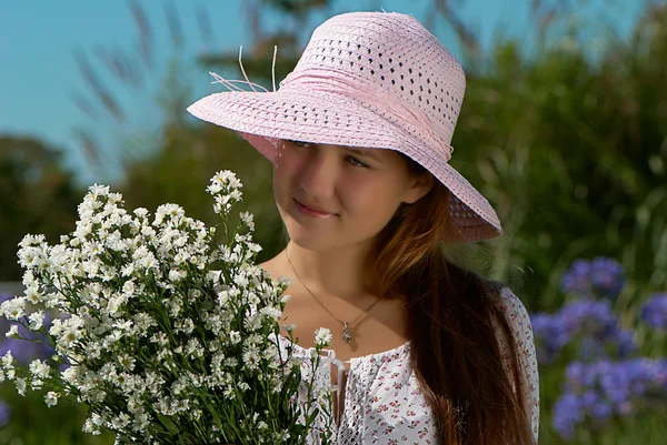 Lány kalapban virágokkal — Stock Fotó