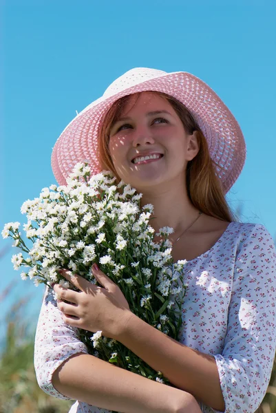 Meisje in de hoed met bloemen — Stockfoto