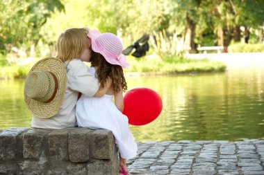 Boy and girl sitting in the park clipart