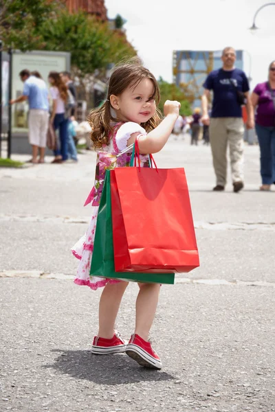 Маленькая девочка с сумками — стоковое фото