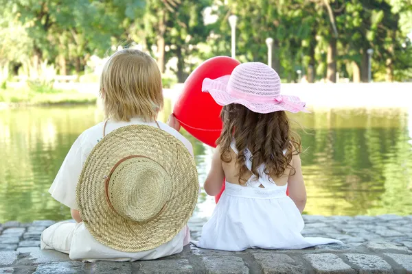 Мальчик и девочка сидят в парке — стоковое фото