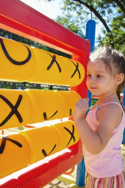 Девушка играет на детской площадке крестики-нолики — стоковое фото