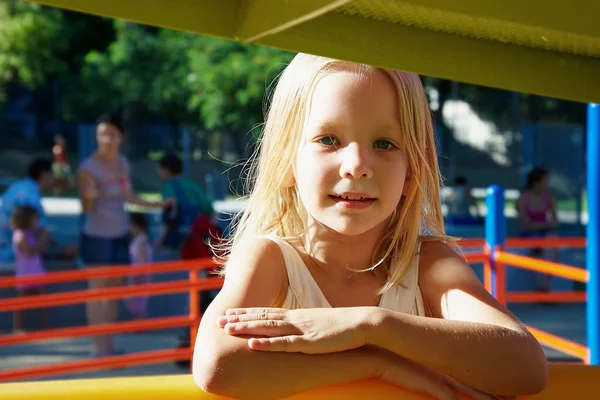 Bambina che cavalca su un'altalena nel parco giochi — Foto Stock