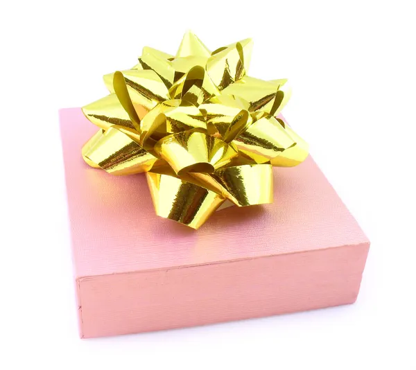 Подарок в розовой упаковке с золотым луком — стоковое фото