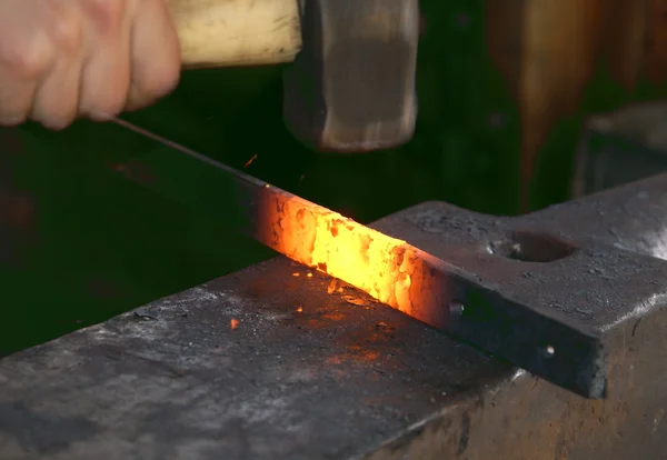 Preparing metal with a hammer in fire — Stock Photo, Image