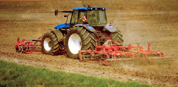Grunge-Bild eines Traktors auf Ackerland — Stockfoto