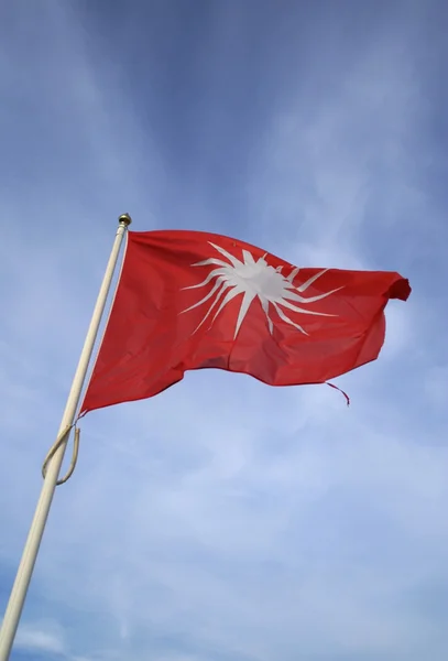 stock image Red flag against a blue sky