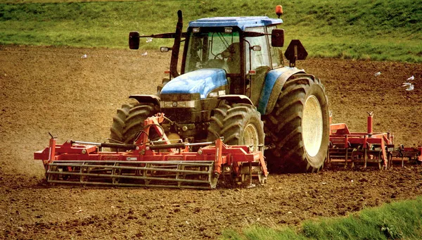 Imagem Grunge de um tractor em terrenos agrícolas Imagem De Stock
