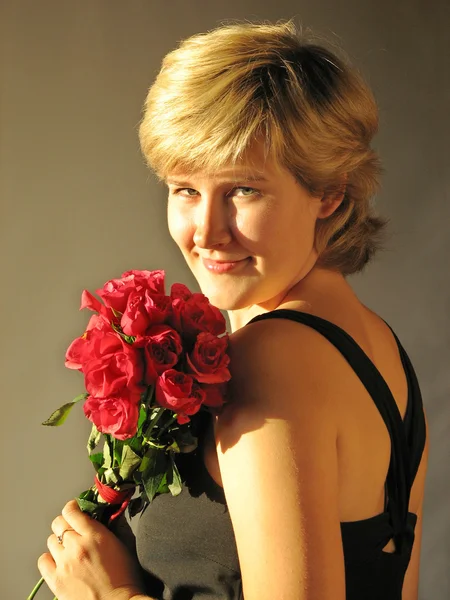 Όμορφη γυναίκα με κόκκινα τριαντάφυλλα — Φωτογραφία Αρχείου