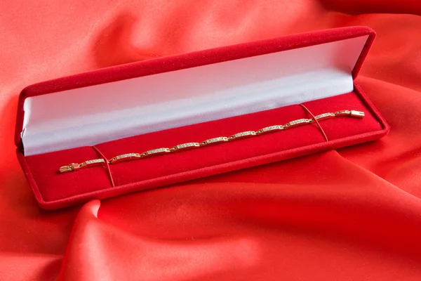 Röda smycken box med guldarmband — Stockfoto