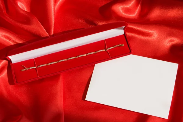 Rote Schmuckschatulle mit goldenem Armband — Stockfoto