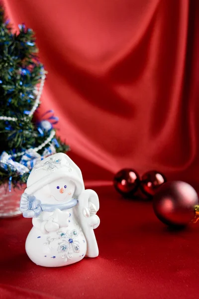 Muñeco de nieve sobre fondo satinado rojo —  Fotos de Stock