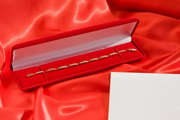 Scatola gioiello rosso con bracciale in oro Fotografia Stock