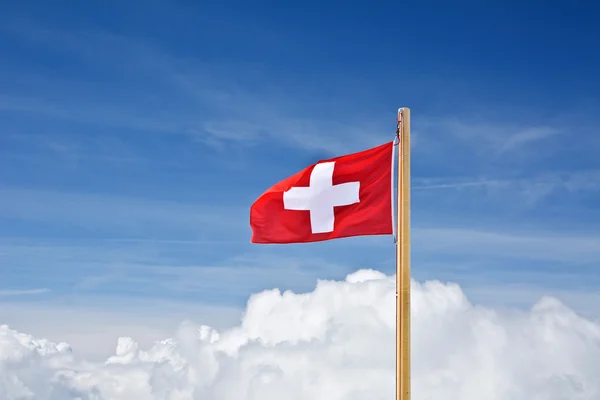 Schweiziska flaggan ovan molnen — Stockfoto