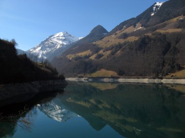 Snowy mountain reflecting in Sarnen see clipart