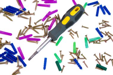 Screws, dowels and screwdriver on white clipart