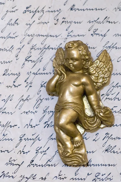 Kleine engel standbeeld op oude brief — Stockfoto