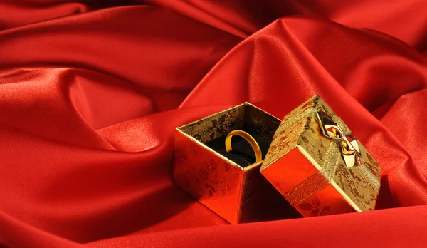 Χρυσά κουτιά με ένα γαμήλιο δαχτυλίδι στο κόκκινο si — Φωτογραφία Αρχείου