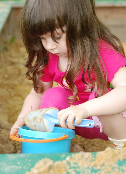 La chica jugando a una caja de arena —  Fotos de Stock