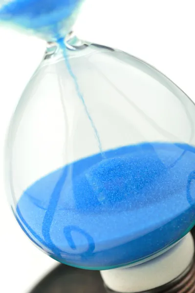 Песчаный стакан на долларах голубой тон — стоковое фото