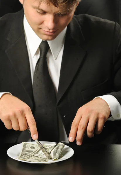 Бизнесмен, обедающий с долларами — стоковое фото