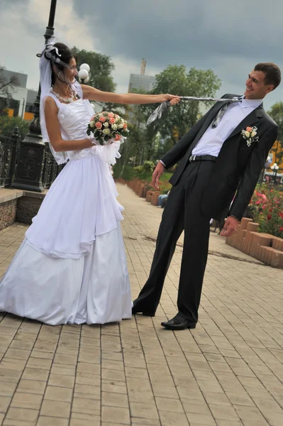A noiva puxa o noivo para uma gravata — Fotografia de Stock