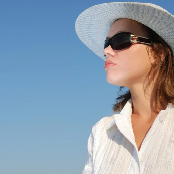 De vrouw in bril en een hoed op een rug — Stockfoto