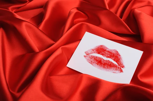 Nota sobre seda vermelha. Uma impressão de lábios — Fotografia de Stock