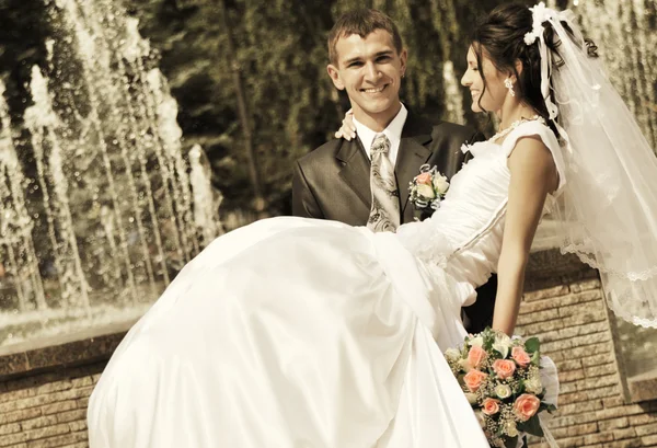 Le marié tient la mariée sur les mains — Photo
